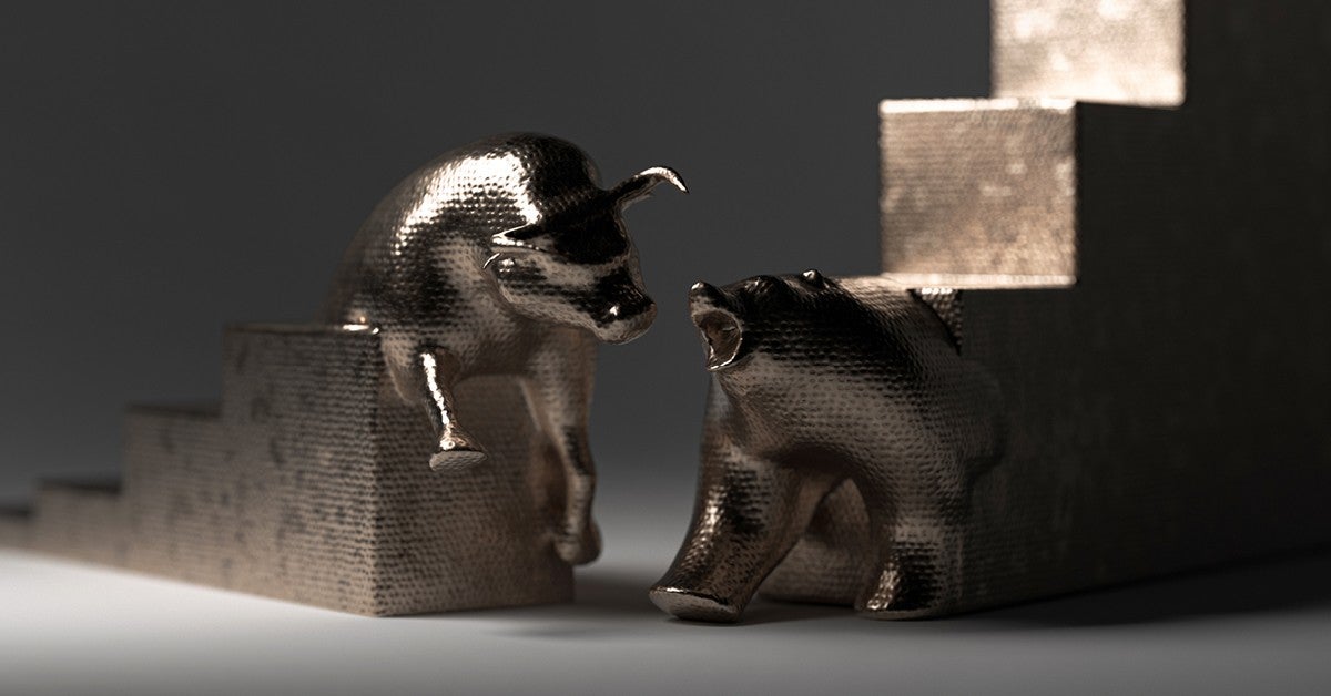 Bull statue and bear statue against grey background