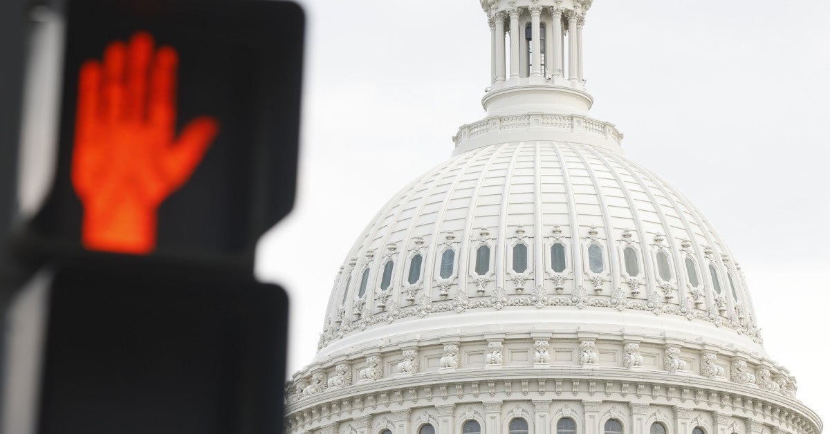 The U.S. Capitol dome and a don't walk traffic sign.