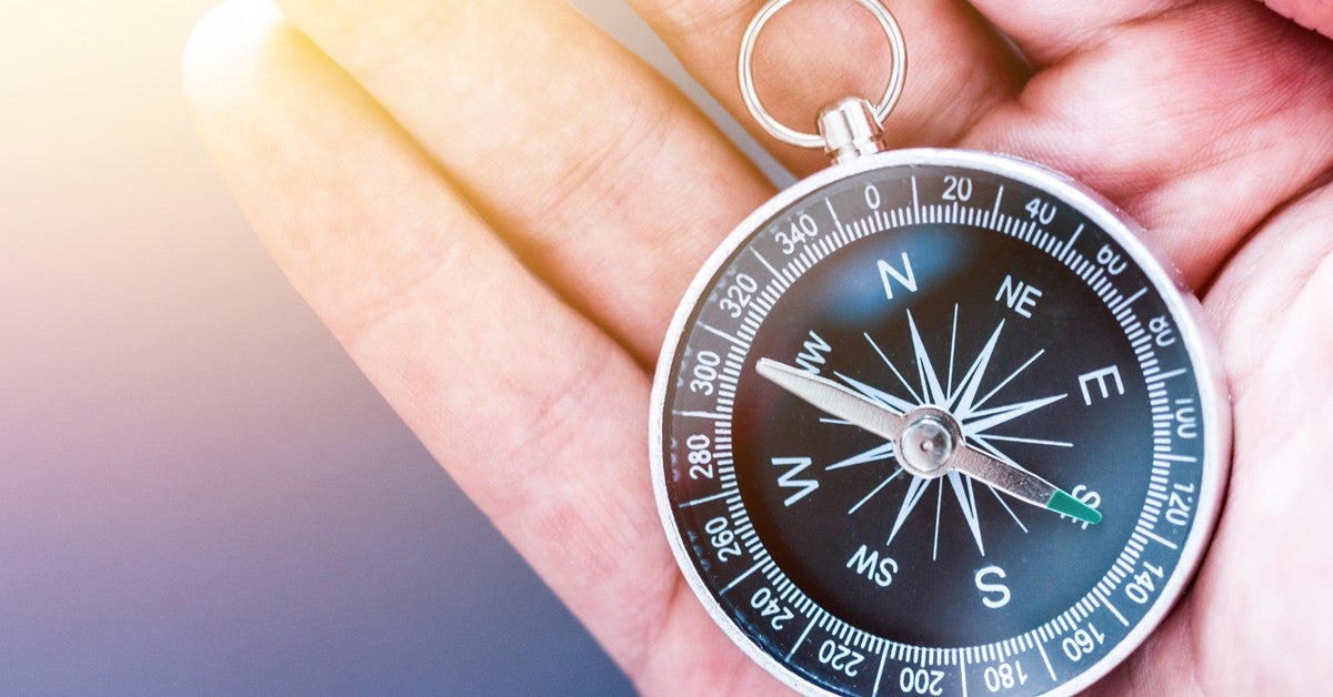 Hand holding a compass