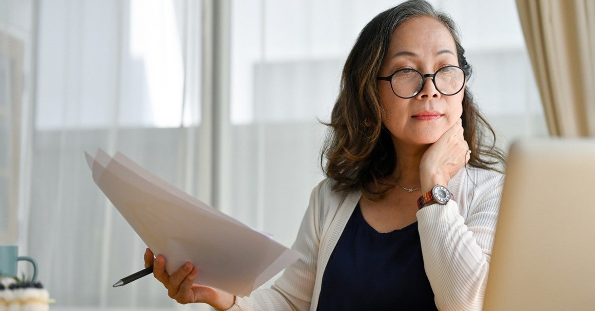 A young businesswoman smiles confidently in a professional office setting, embodying success and professionalism.