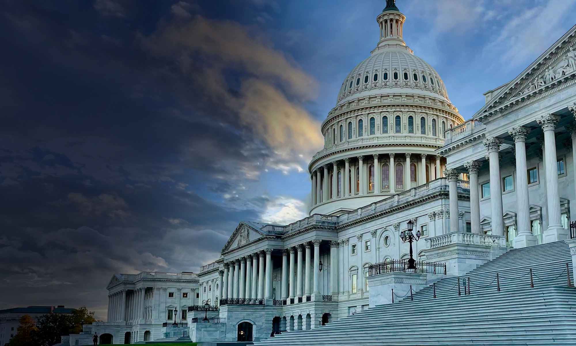 The iconic United States Capitol building is captured under a dramatic evening sky. The neoclassical architecture is highlighted by soft lighting, emphasizing its grandeur and historical significance. The steps leading to the entrance are visible, adding depth to the composition.