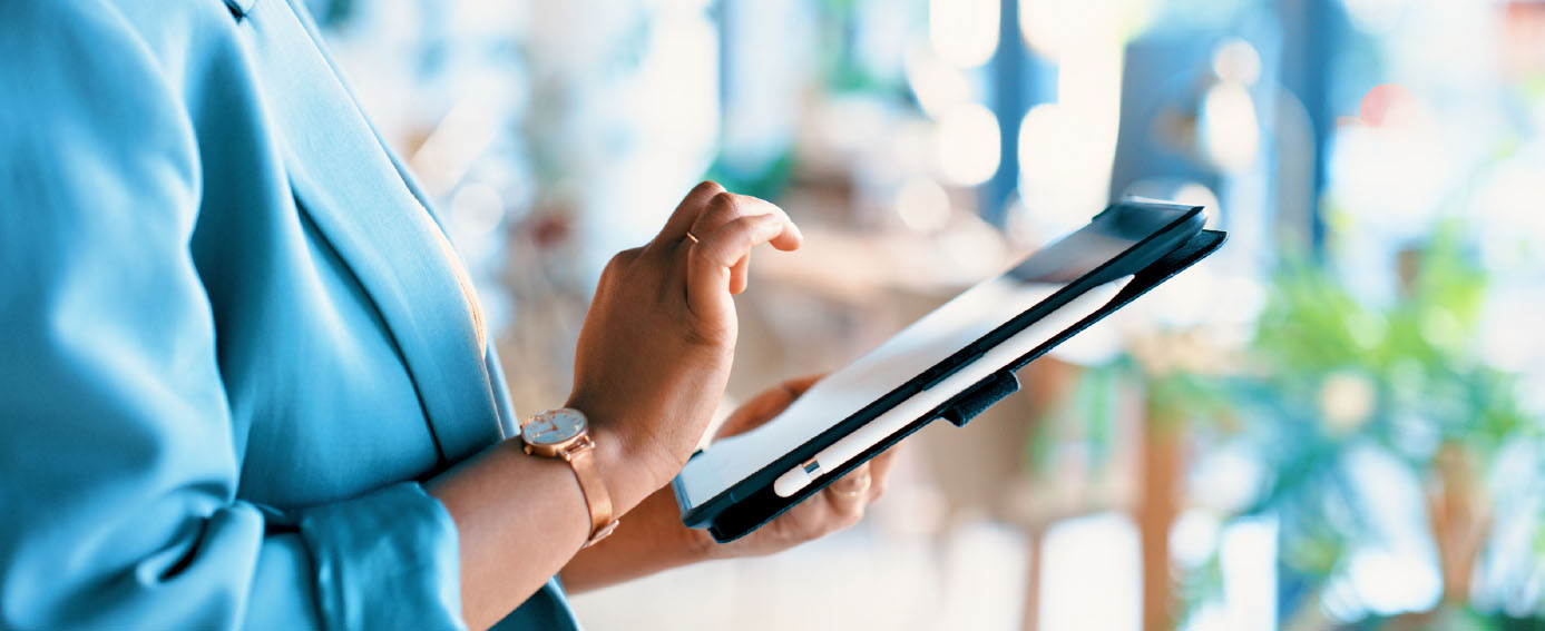 A woman interacts with a tablet in a modern office, highlighting the role of technology in business communication.