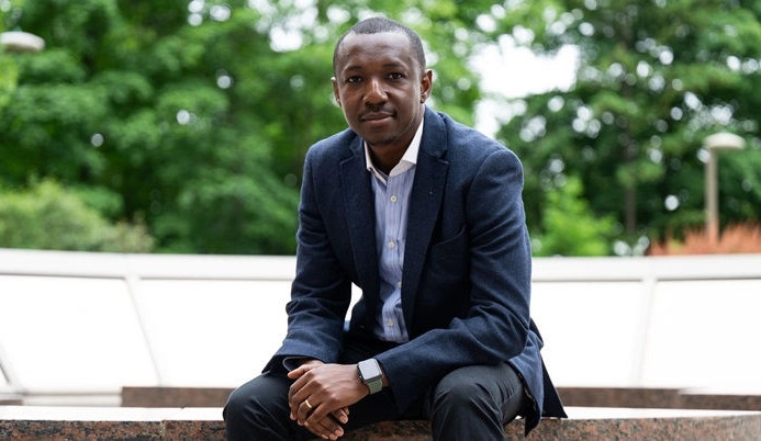 Upward view of modern skyscrapers and the CN Tower against a colorful sunset sky with soft pink and blue clouds.
