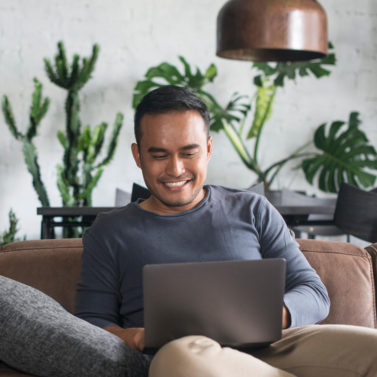 An adult businessman is working from home, using his laptop to access the internet for professional tasks.
