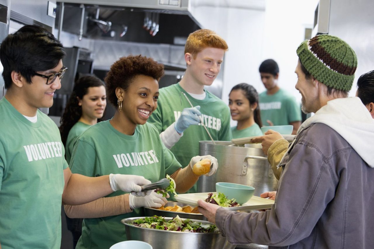 Volunteers in green shirts at a soup kitchen