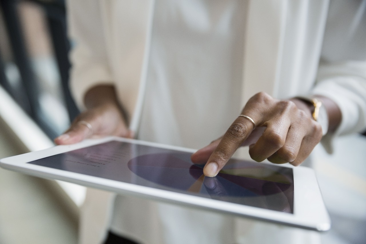 Close up businesswoman reviewing pie chart on digital tablet