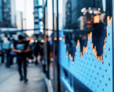 outside street with a market stock chart on a screen