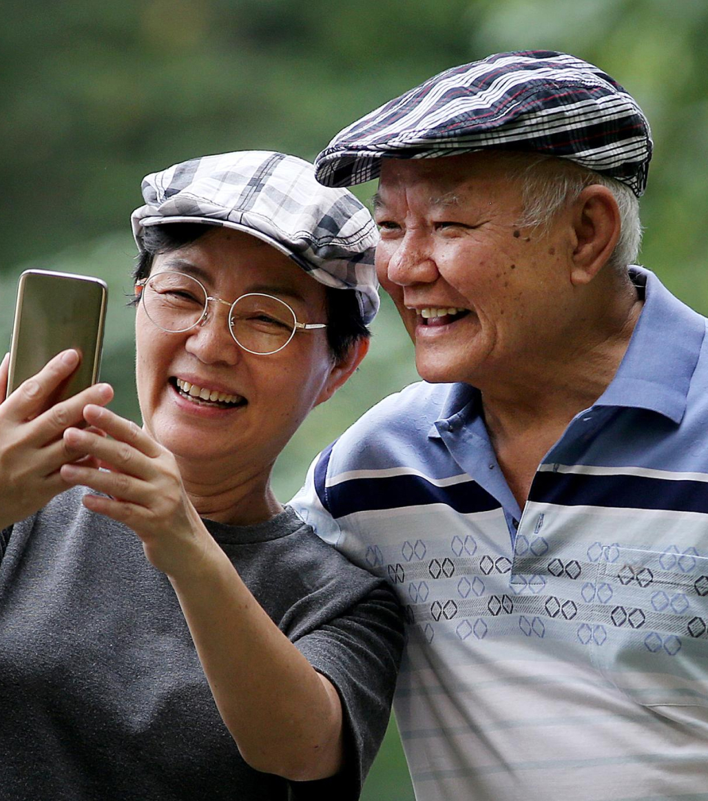 older couple smiling and looking at a phone