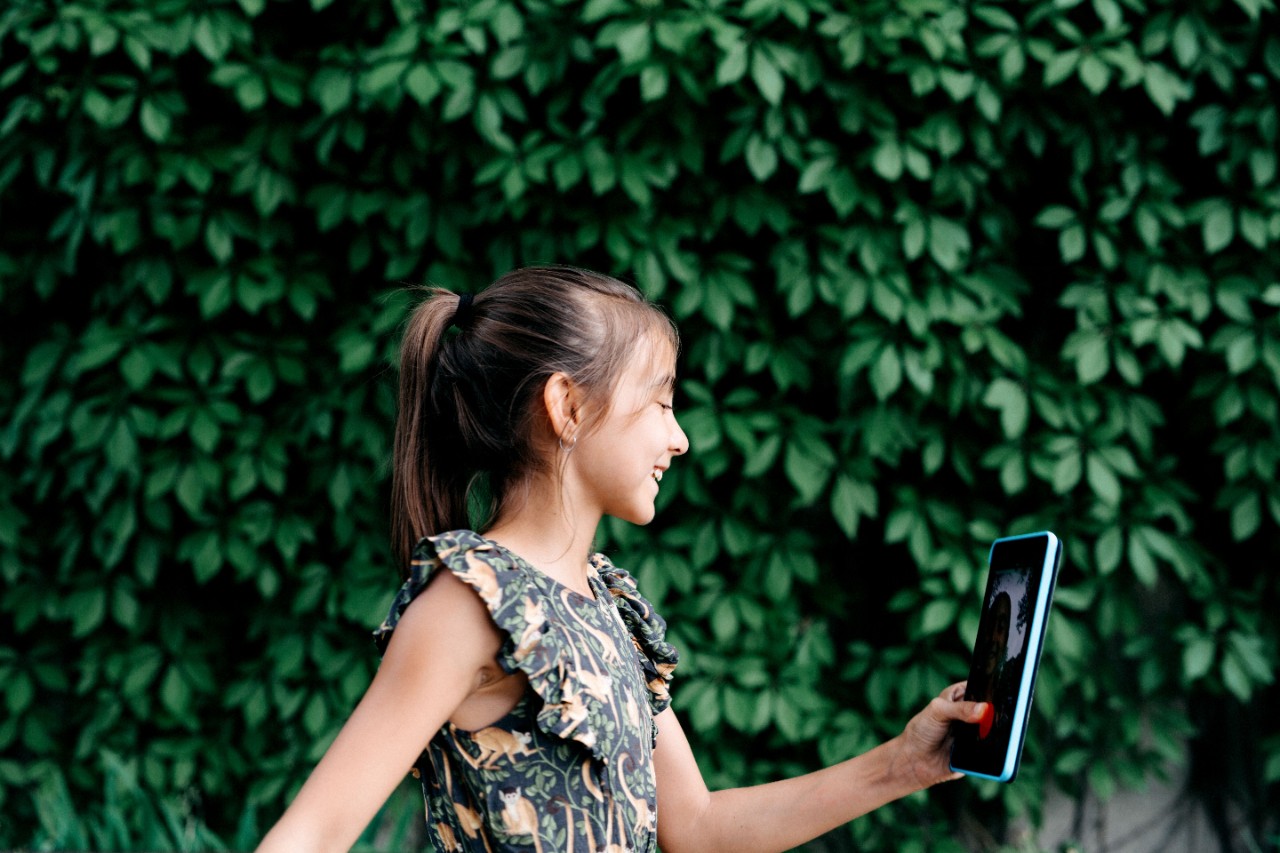 Young girl using a tablet in the street