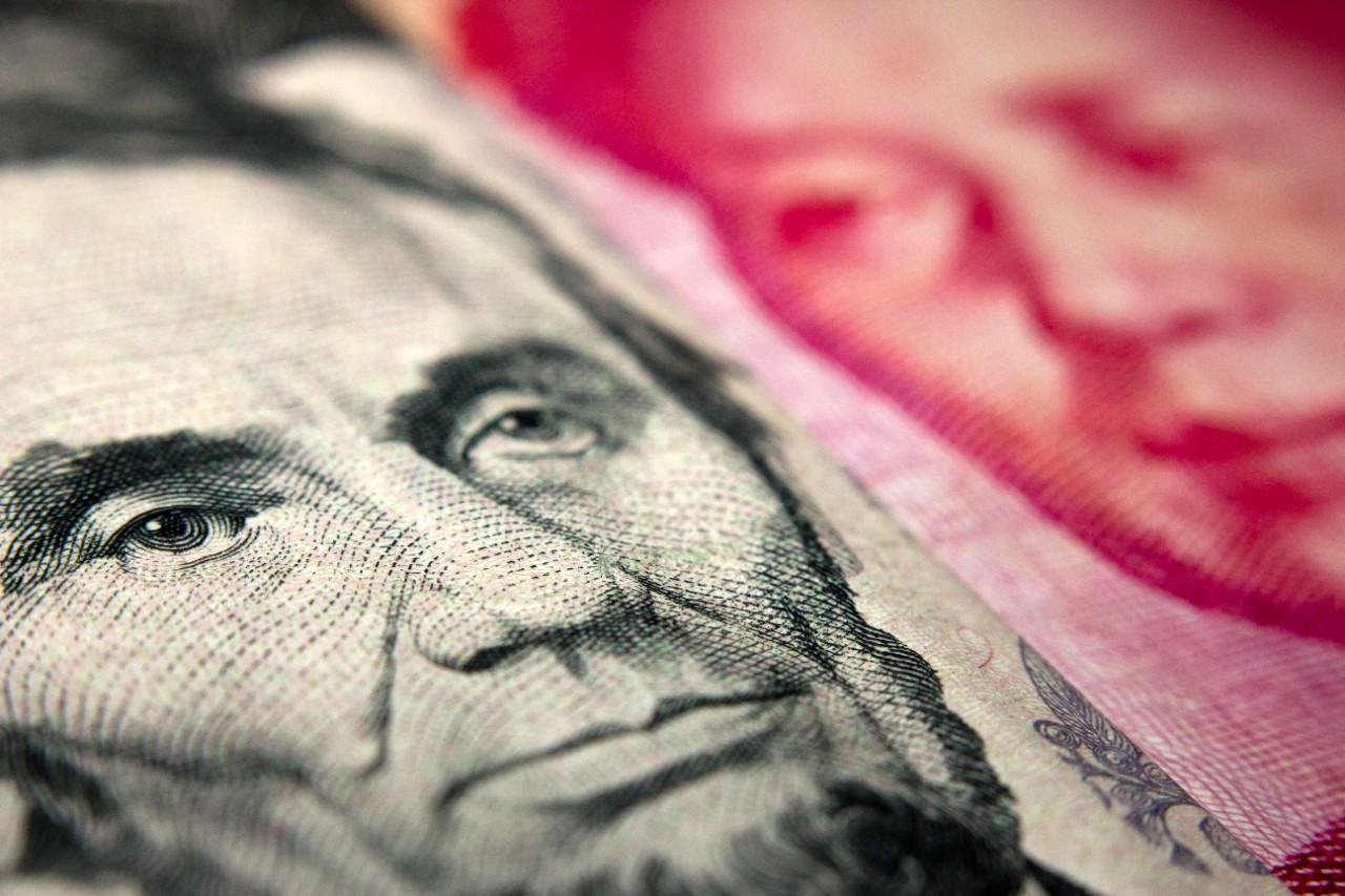 Close-up of an American banknote (showing Lincoln) and a Chinese yuan banknote (Mao Zedong)