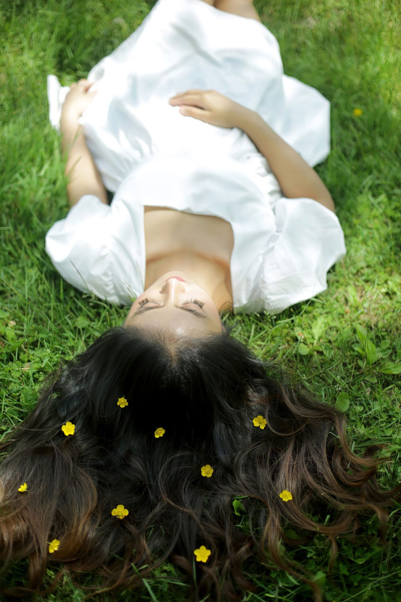 Woman lying in grass with flowers in her hair