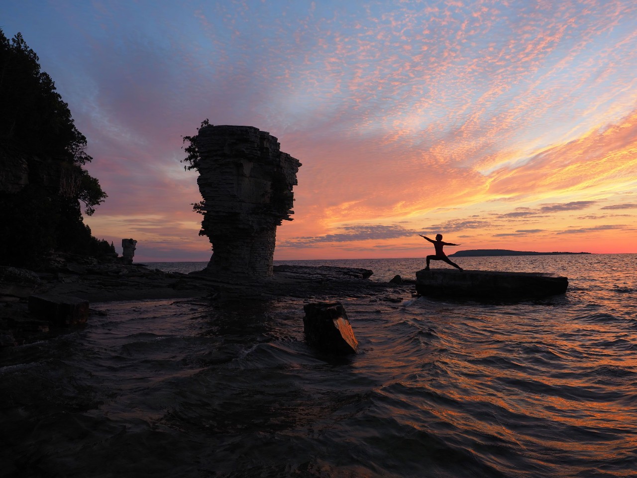 Woman doing yoga at sunset on rocks at Flowerpot Island