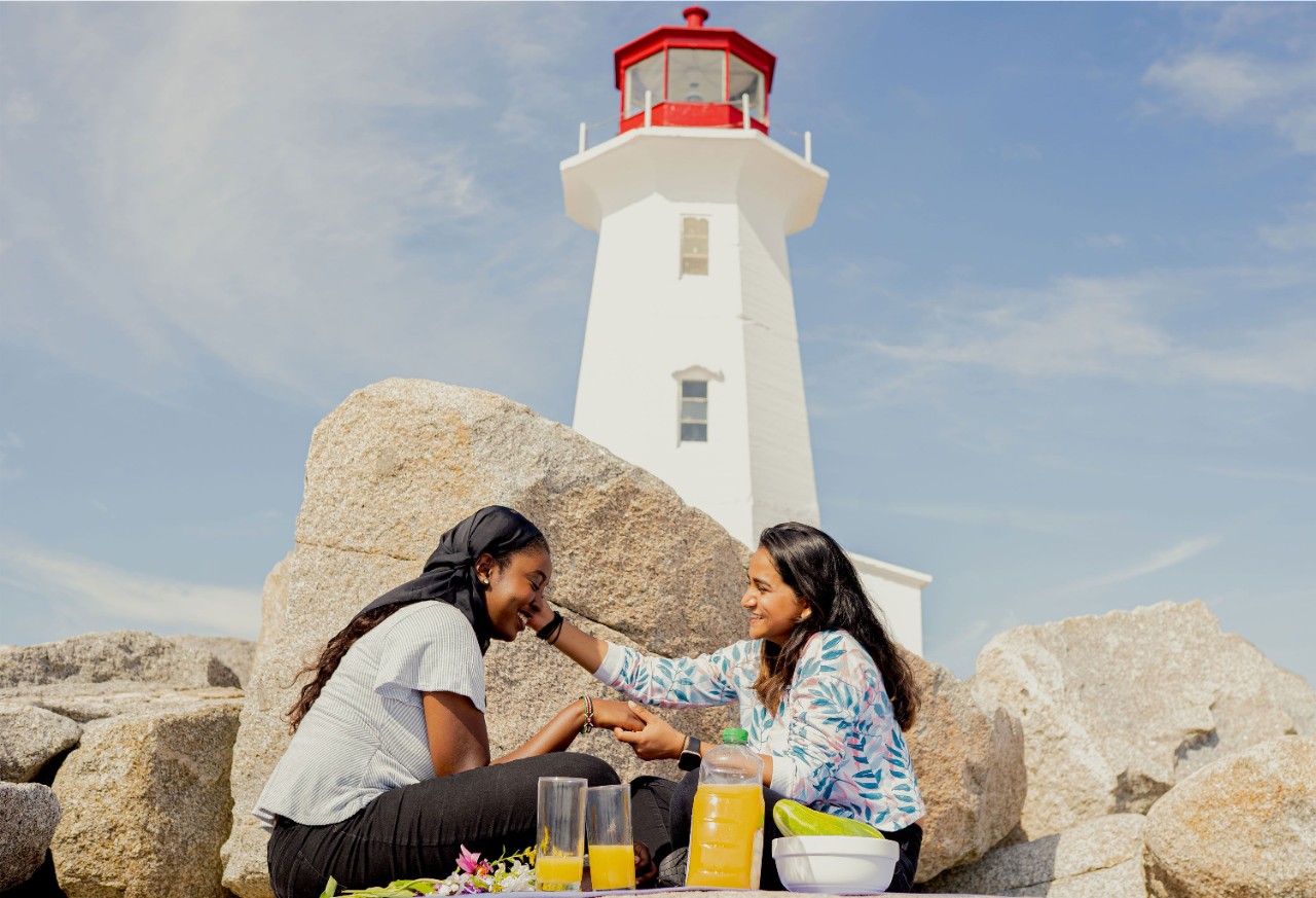Women having a picnic in front of lighthouse